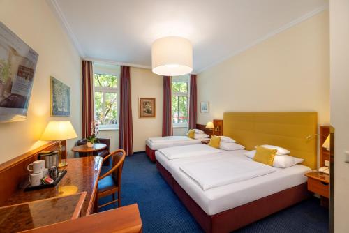 a hotel room with two beds and a table at Austria Classic Hotel Wien in Vienna