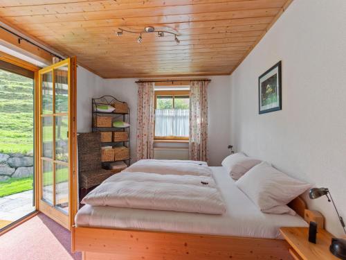 a large bed in a room with a window at Alpenapartment mit Garten in Trauchgau