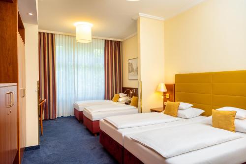 a hotel room with four beds in a row at Austria Classic Hotel Wien in Vienna