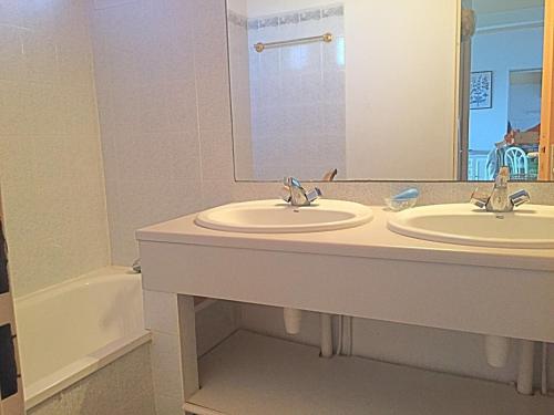 a bathroom with two sinks and a mirror and a tub at Savanna Beach in Cap d'Agde