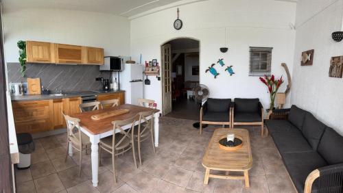a living room with a couch and a table at TIANOLI lodge grand confort avec vue magnifique in Sainte-Anne
