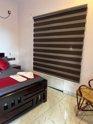 a bedroom with a bed and a chair and a window at Sea Hilz Beach Resort in Varkala