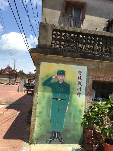 a painting of a soldier on the side of a building at Ancient Official Road Homestay in Jinhu