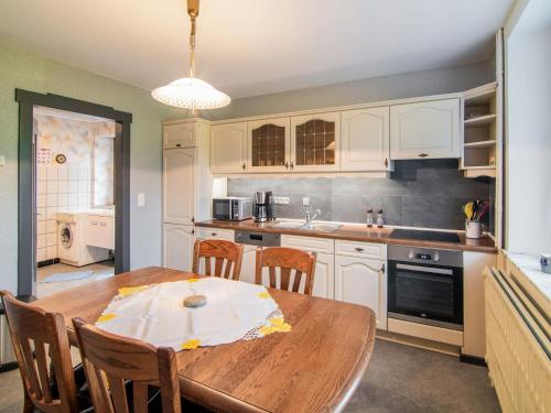a kitchen with a wooden table with chairs and a dining room at Holiday Home in Bullingen with Garden in Bullange