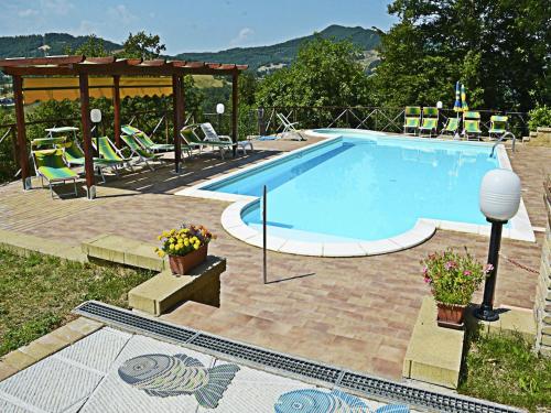 a swimming pool with chairs and a gazebo at Country Cottage in Marche with Swimming Pool in Apecchio