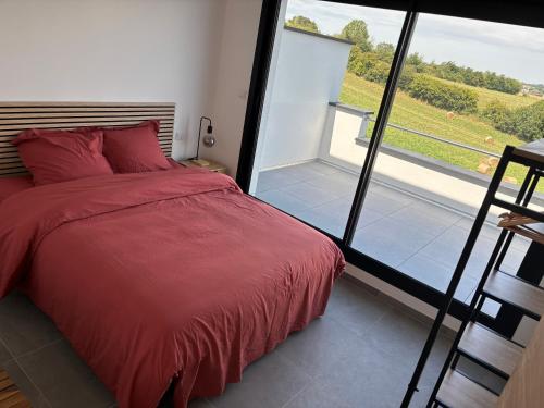 Schlafzimmer mit einem roten Bett und einem großen Fenster in der Unterkunft La Vallée des Biches G2 in Saint-Martin-Boulogne