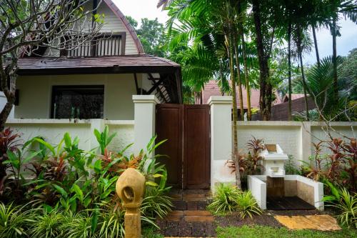 a house with a wooden door and a fence at Barali Beach Resort Koh Chang in Ko Chang