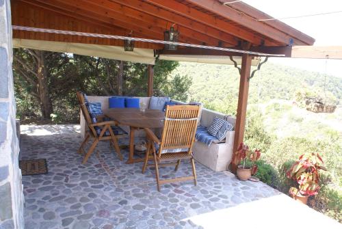 a patio with a table and chairs under a pavilion at O Ioannis in Kritinía