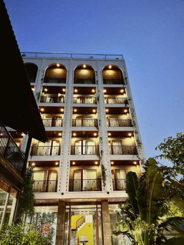 a tall white building with lights on it at Eden Hotel Cát Bà in Cat Ba