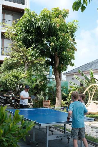 two boys playing ping pong on a ping pong table at Eden Hotel Cát Bà in Cat Ba
