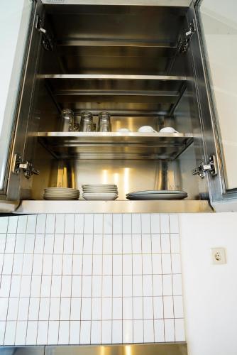 a microwave oven with plates and dishes in it at Charming cozy House in Yogya, 15Min from Prambanan in Kalasan