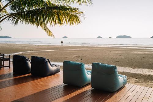 four pairs of shoes sitting on a table near the beach at Barali Beach Resort Koh Chang in Ko Chang