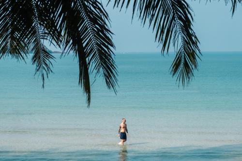 a man standing in the water on the beach at Barali Beach Resort Koh Chang in Ko Chang