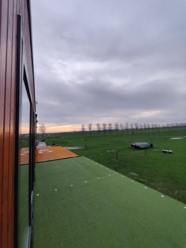 a view of a field from a window of a building at Betuwe Lodge 1 in Tricht