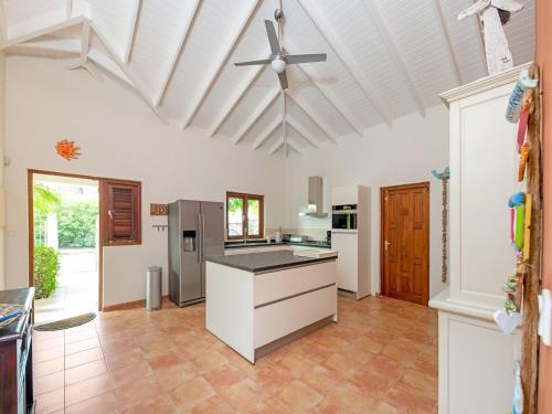 een keuken met witte kasten en een plafondventilator bij Holiday villa at Jan Thielstrand in Willemstad in Jan Thiel
