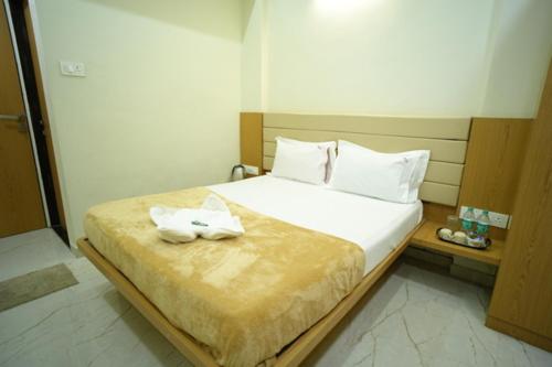 a bedroom with a bed with two towels on it at Hotel Sai Pratham in Shirdi