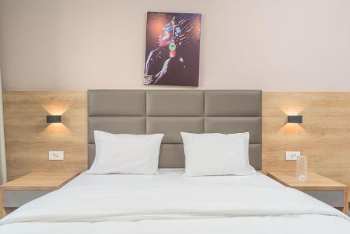 a bedroom with a large bed with white sheets at Grey - Elegant Apartments in Awkar in Dbayeh