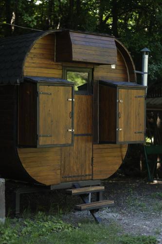 a wooden hobbit house sitting in the grass at Owl Glamping House DIlijan in Dilijan