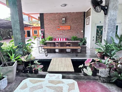 a patio with a couch and a table and potted plants at พี เค ซี รีสอร์ท in Prakhon Chai