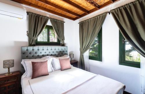 - une chambre avec un grand lit blanc et des fenêtres dans l'établissement The Regency Cottage, à İslâmlar