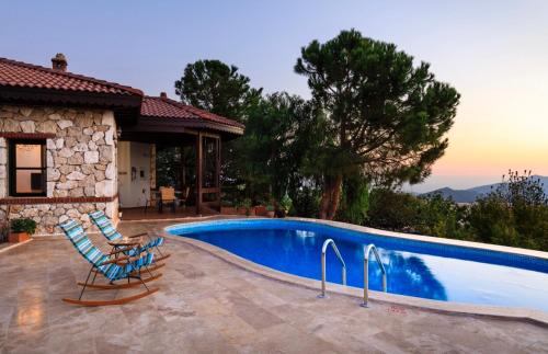 une piscine avec deux chaises à côté d'une maison dans l'établissement The Regency Cottage, à İslâmlar