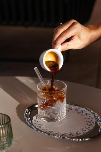 a person pouring a drink into a cup on a table at Weinlandhof in Gamlitz