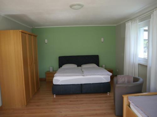 a bedroom with a bed and a chair at Ferienwohnung in Löwensen mit eigener Terrasse in Bad Pyrmont