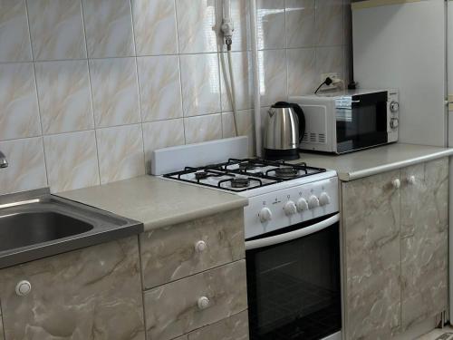 a kitchen with a stove and a microwave at 2-к квартира в Черновцах in Chernivtsi
