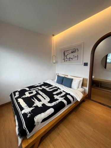 a bedroom with a bed with a black and white blanket at COCO HOUSE Bùi Thị Xuân, Đà Lạt in Da Lat