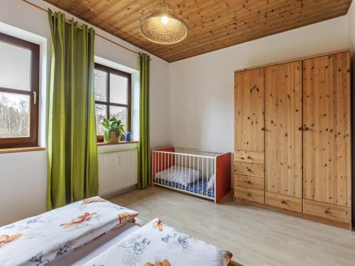a bedroom with two beds and a crib at Alluring Apartment in Schönsee in the forest in Schönsee