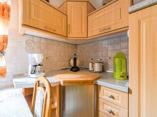 a kitchen with wooden cabinets and a counter top at Ferienwohnung in der Nähe des Brockengipfels in Ilsenburg