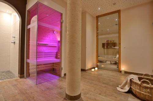 a bathroom with a shower with purple lighting at Hotel Astoria in Serfaus