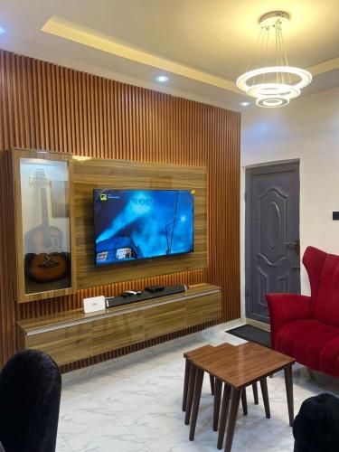 a living room with a red couch and a flat screen tv at Melford Homes in Lagos