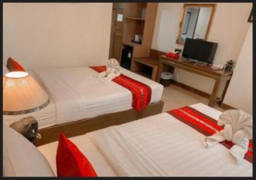 a hotel room with two beds and a desk at Aiyaree Place Hotel SHA PLUS in Jomtien Beach