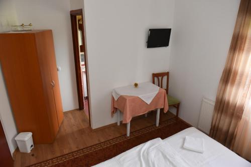 a room with a table and a tv and a bed at Bistro Kristina in Perušić