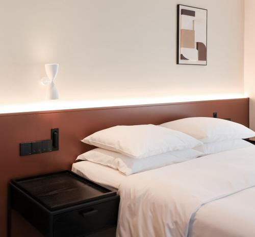 a bedroom with two beds with white pillows and a headboard at Citadines Connect Chayuan Chongqing in Changshengqiao