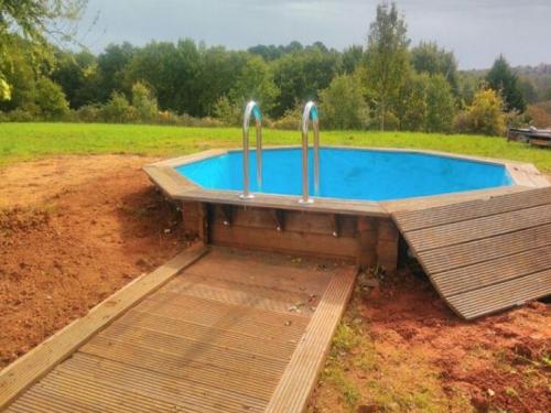 einen Pool auf einem Feld mit einer Holzterrasse in der Unterkunft Tranquil Garden Hideaway in Puy-lʼÉvêque
