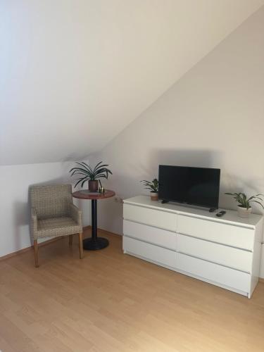 a living room with a tv on a white dresser at Međimurski San in Lopatinec