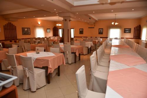 a banquet hall with white tables and white chairs at Bistro Kristina in Perušić