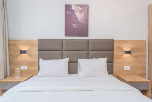 a bedroom with a large bed with white pillows at Grey - Elegant Apartments in Awkar in Dbayeh