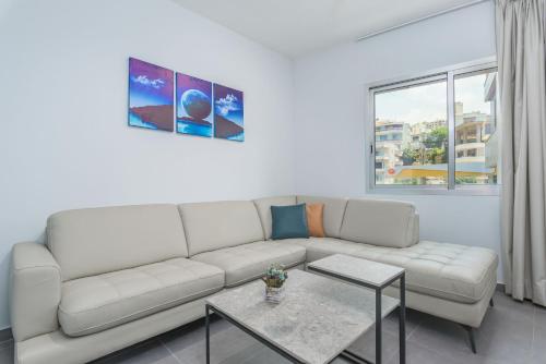 a living room with a white couch and a table at Grey - Elegant Apartments in Awkar in Dbayeh