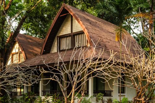 a house with a brown roof and a tree at Barali Beach Resort Koh Chang in Ko Chang