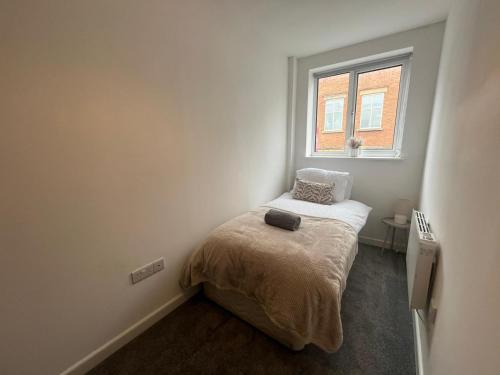 ein kleines Schlafzimmer mit einem Bett und einem Fenster in der Unterkunft Hunters House Flat 6 Sleeps 3 long stays Free Wi-Fi in Swindon