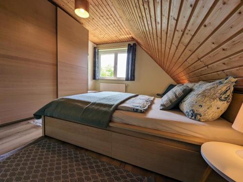 a bedroom with a large bed with a wooden ceiling at Spacious appartment in Wilhelmshof near Lake in Wilhelmshof