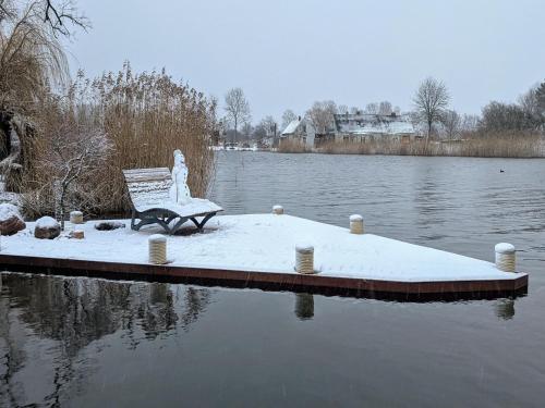 a bench sitting on a dock next to a body of water at Spacious appartment in Wilhelmshof near Lake in Wilhelmshof