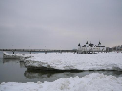 a pier covered in snow next to a body of water at Spacious appartment in Wilhelmshof near Lake in Wilhelmshof