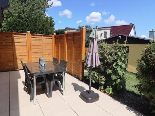 a patio with a table and an umbrella at Spacious appartment in Wilhelmshof near Lake in Wilhelmshof