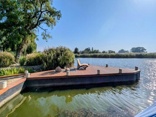 a dock on a lake with a chair on it at Spacious appartment in Wilhelmshof near Lake in Wilhelmshof