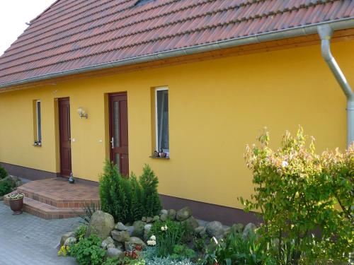a yellow house with a red roof at Spacious appartment in Wilhelmshof near Lake in Wilhelmshof