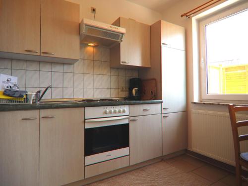 a kitchen with a stove top oven next to a window at Spacious appartment in Wilhelmshof near Lake in Wilhelmshof